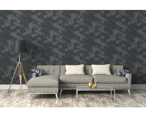 Woonkamer met grijze bank, staande lamp en muur met hexagoonpatroon