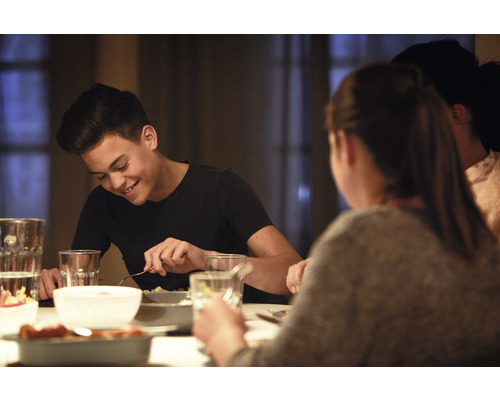 Een scène van een gezellig diner aan tafel met familie of vrienden.