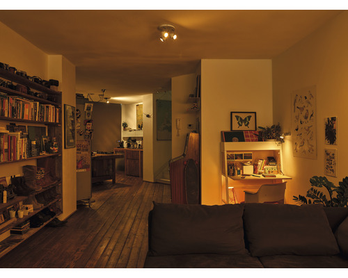 Woonkamer met boekenkast, bureau en sofa