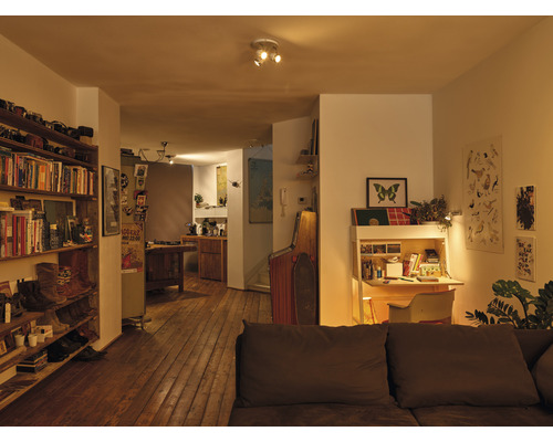 Woonkamer met boekenkast, bureau en houten vloer