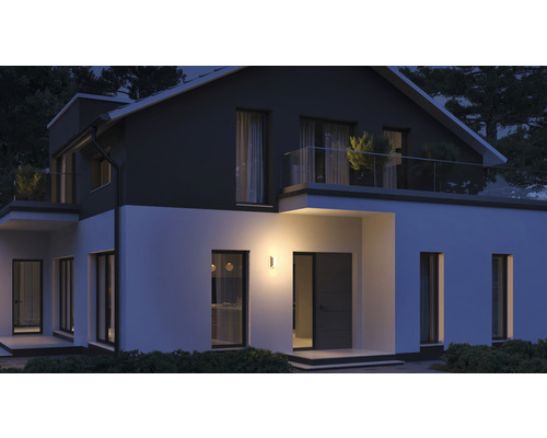 Verlicht woonhuis met buitenwandlamp ''s nachts