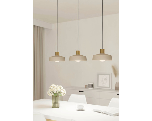 Drie metalen hanglampen boven een eettafel