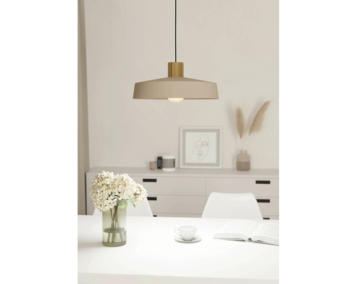 Beige hanglamp boven een eettafel in een lichte ruimte.