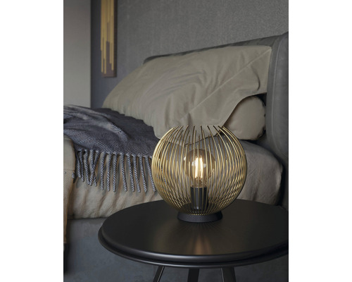 Decoratieve tafellamp met bolvormig draadframe op een nachtkastje