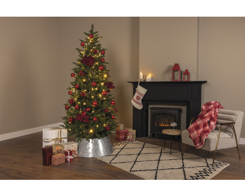 Kerstboom met rode versiering en cadeaus in de woonkamer met open haard
