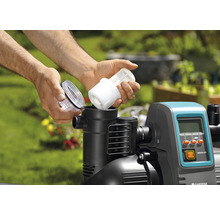 Man plaatst filter in een hydrofoorpomp in de tuin.