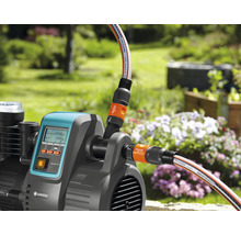 Tuinpomp met aangesloten tuinslangen buitenshuis.
