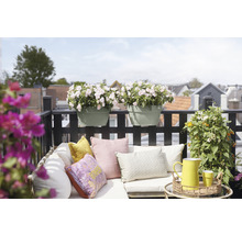 Gedecoreerd balkon met bloembakken, kussens en tuinmeubilair voor een gezellige sfeer