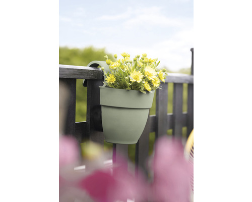 Hangende bloempot met gele bloemen aan een balkonreling