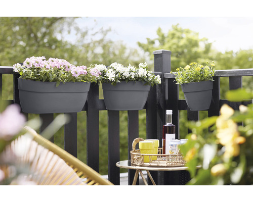 Balkonscène met bloembakken aan de reling en drankjes op een tafel