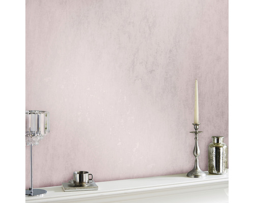 Roze behang met kandelaar, vaas en theekopje op een schouw