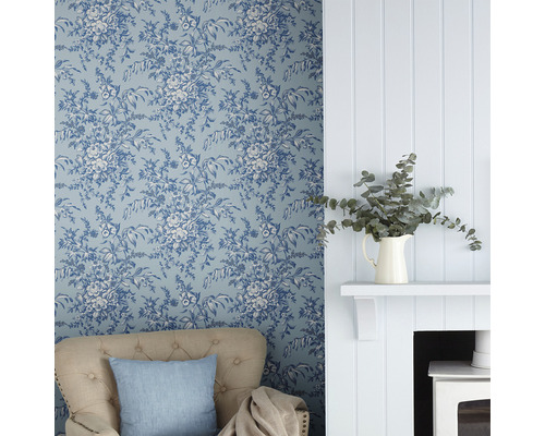 Woonkamer met bloemenbehang, fauteuil en open haard