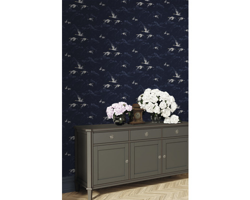 Scene met behang met vogelmotief, dressoir, bloemen en klok.