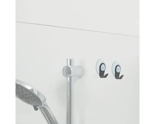 Twee haken met zuignappen in de badkamer naast een douchearmatuur