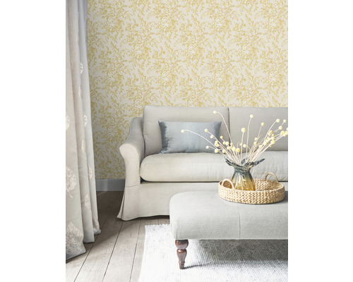 Woonkamer met bank, kruk en behang met bloemenmotief