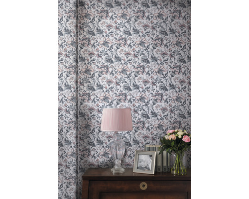 Decoratieve kamer met bloemetjesbehang, tafellamp, bloemenboeket en fotolijst op een commode