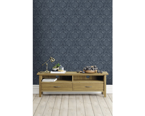 Woonkamer met blauw patroonbehang en houten meubels