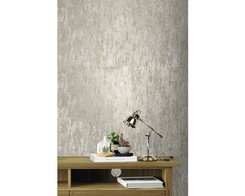 Close-up van een gestructureerd behang boven een houten meubel met lamp en decoratie