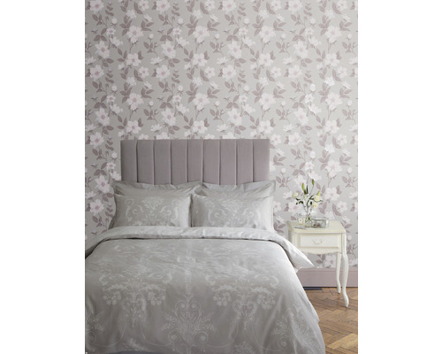 Slaapkamer met bed, nachtkastje en bloemenbehang