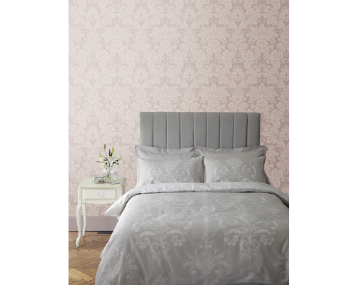 Slaapkamer met bed, nachtkastje en behang met motief