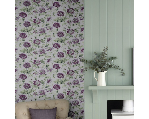 Woonkamer met bloemenbehang, houten lambrisering en decoraties voor een harmonieus interieur.