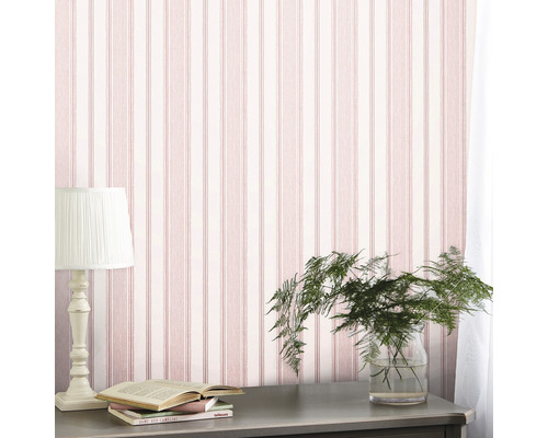 Scene met gestreept behang, tafellamp, plant in glas en boeken