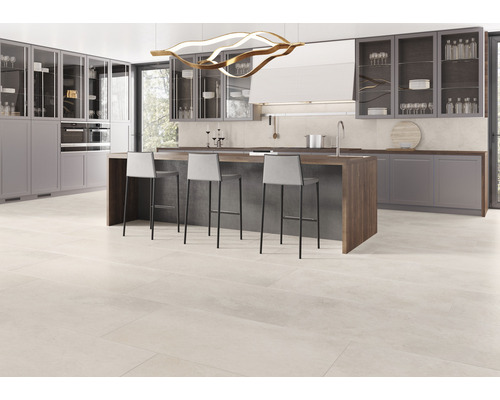 Lichte, moderne keuken met kookeiland, barkrukken en tegelvloer.