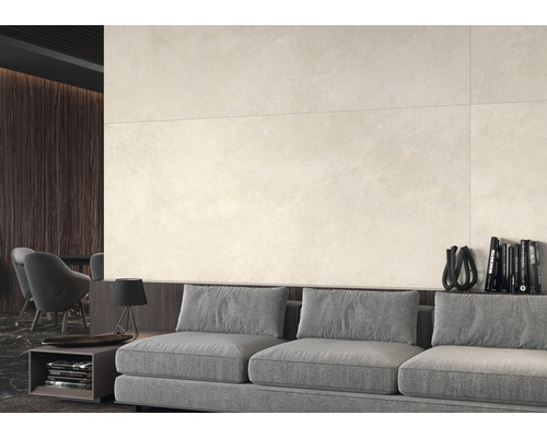 Beige wandtegels boven een grijze bank in een woonkamer