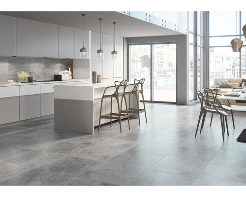 Lichte woonkamer met grijze vloertegels, kookeiland en zitgelegenheid