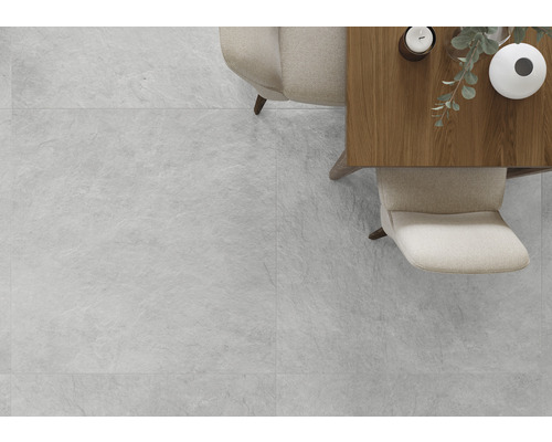 Lichte ruimte met tegels in steenlook, tafel en stoelen.