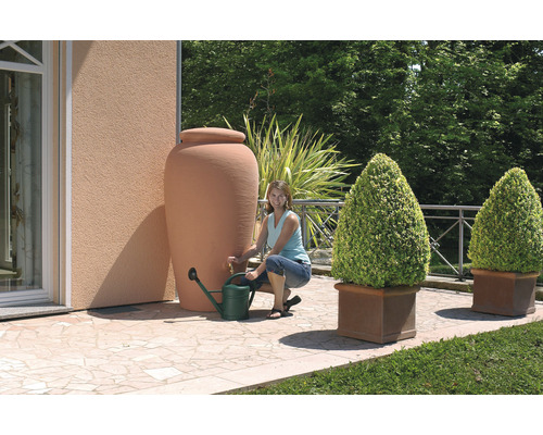 Tuin met regenwatertank, gieter en beplante bloempotten