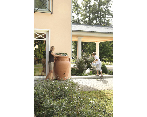 Vrouw bij regenton in amfora-vorm en kind dat planten water geeft in de tuin