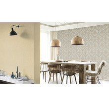Eetkamer met eettafel, stoelen, behang en lampen.