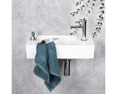 Witte opzetwastafel met kraan, zeepdispenser en handdoek