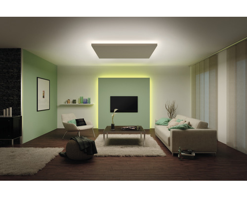 Woonkamer met plafondlamp, bank, fauteuil en televisie