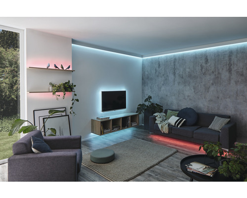 Woonkamer met bank, fauteuil, planken en indirecte verlichting