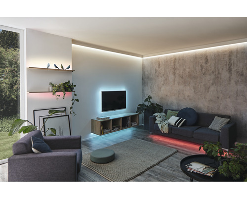 Woonkamer met bank, fauteuil, planken en LED-verlichting