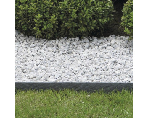 Close-up van decoratief grind in de tuin met gazon en struiken