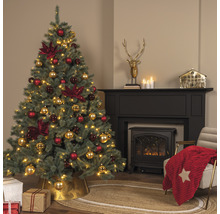 Kerstboom met rode en gouden kerstornamenten in een woonkamer met open haard