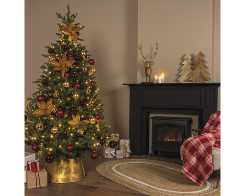 Feestelijk versierde kerstboom naast een open haard met decoraties en geschenken
