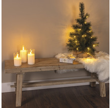 Decoratieve scène met bank, kaarsen, kleine kerstboom, geschenk en een vachtkleed voor een feestelijke sfeer