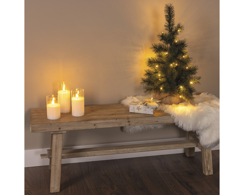 Decoratieve scène met bank, kaarsen, kleine kerstboom, geschenk en een vachtkleed voor een feestelijke sfeer