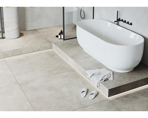 Badkamer met vrijstaand bad, tegelvloer en wastafel