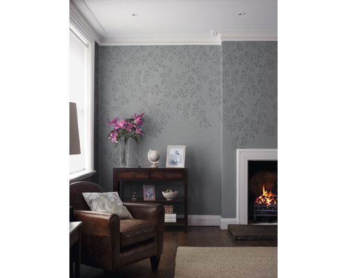 Woonkamer met fauteuil, open haard en decoratief behang