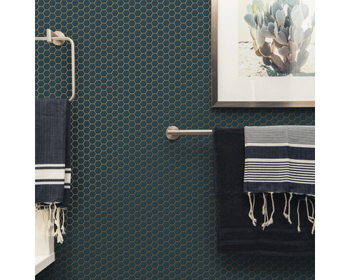 Badkamerwand met zeshoekige mozaïektegels, handdoekhouders en handdoeken