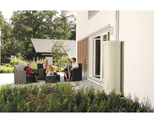 Familie zit op het terras met tuinmeubelen naast een regenwatertank.