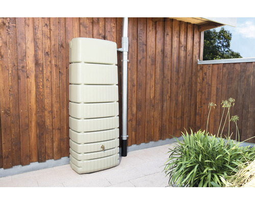 Regenwatertank van kunststof naast een regenpijp tegen een houten wand