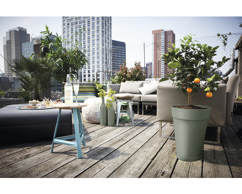 Daktuin met zithoek, tafel en potplanten tegen een stadsachtergrond