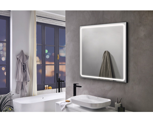 Moderne badkamer met verlichte spiegel, wastafel en bad