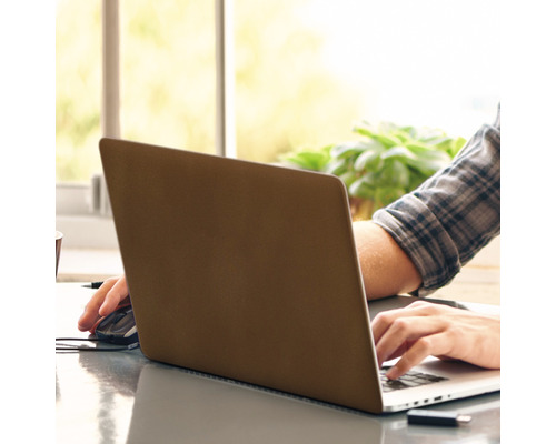 Persoon werkt aan een laptop met muis op een tafel.